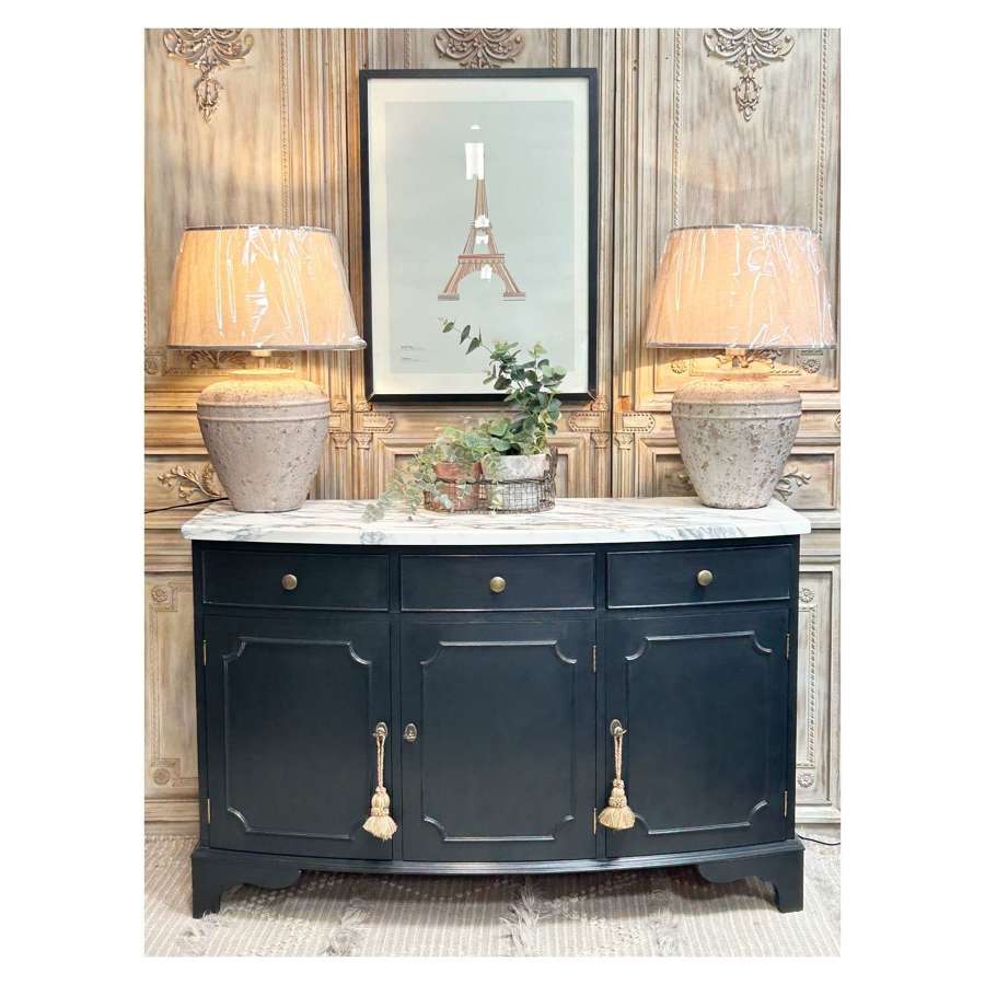 A totally stunning curved black sideboard with a beautiful marble top.